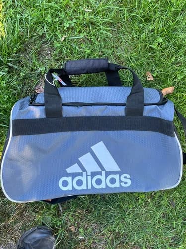 ADIDAS GRAY AND BLACK DUFFEL BAG FOR SPORTS EQUIPMENT SHOULDER STRAPS AND CARRY.